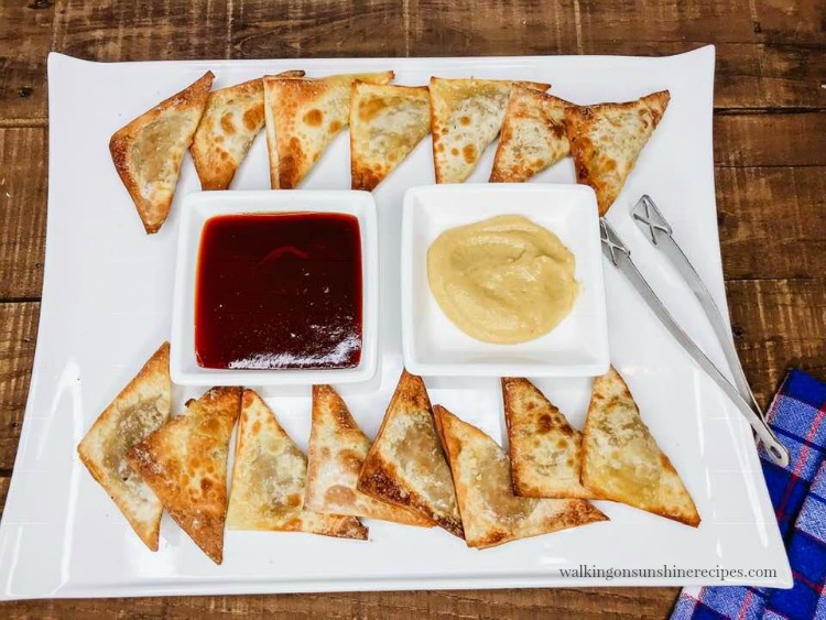 wontons in air fryer cooked and on white platter. 