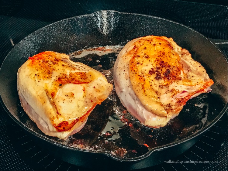 Chicken Breasts seared in Cast Iron Pan ready to go in oven from Walking on Sunshine Recipes
