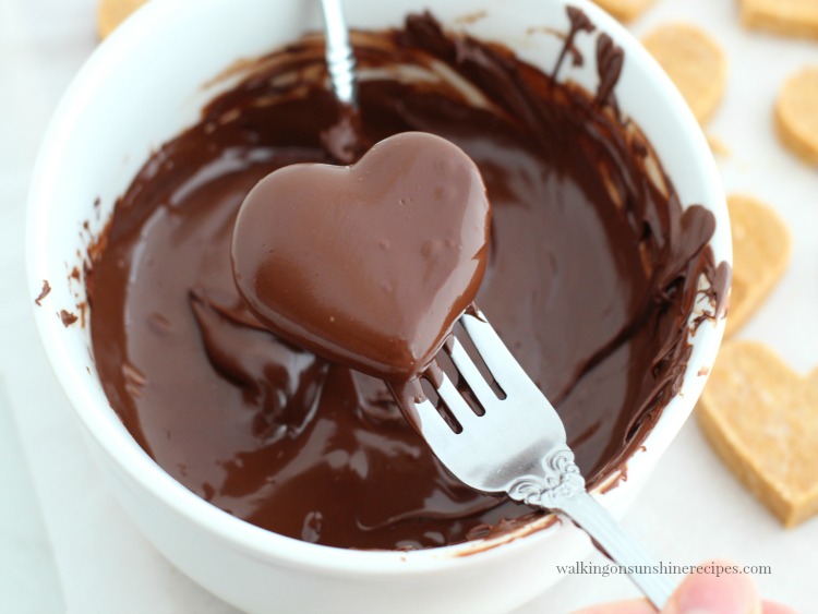 Dip the peanut butter hearts in melted chocolate. 