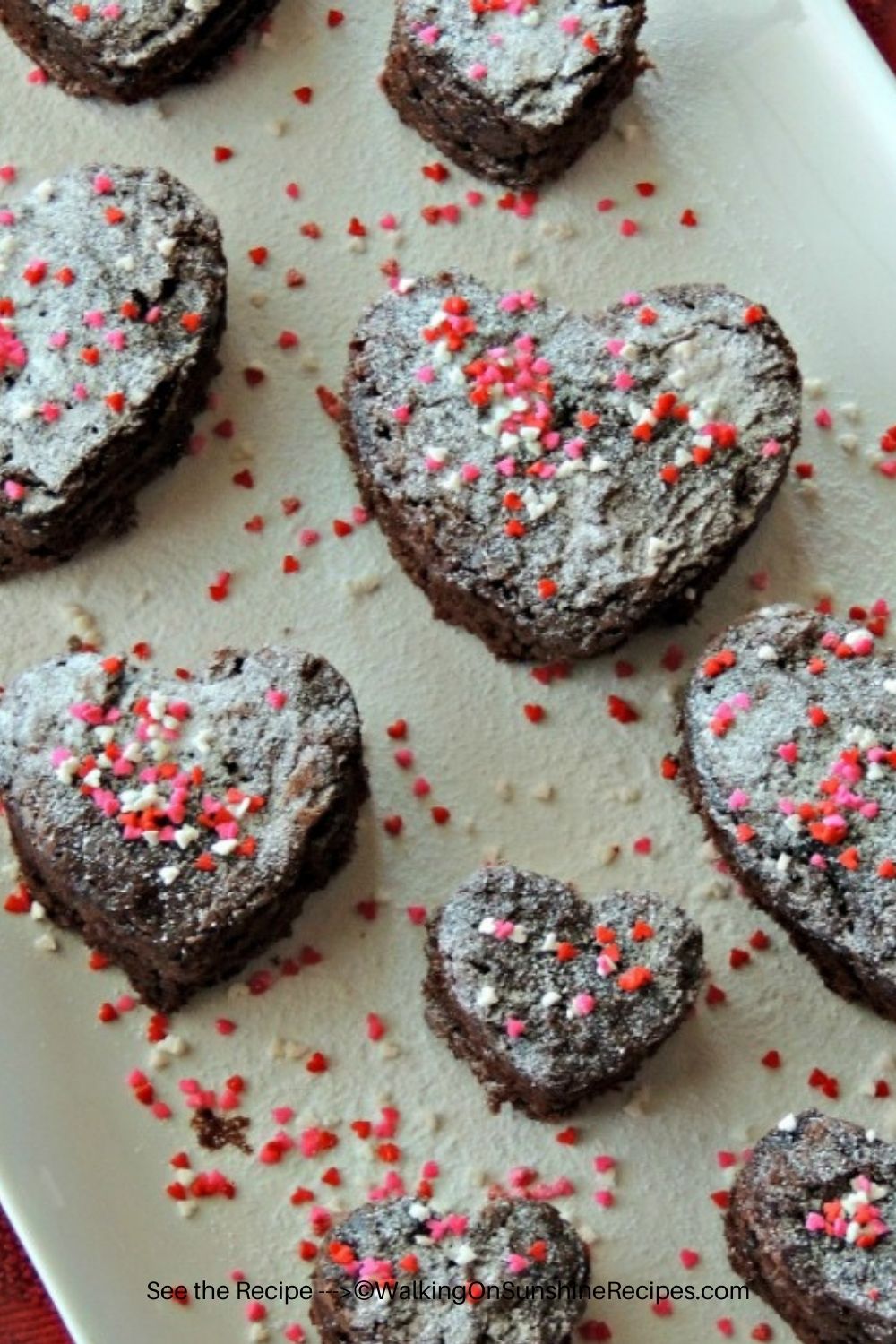 heart shaped brownies with powdered sugar and sprinkles. 