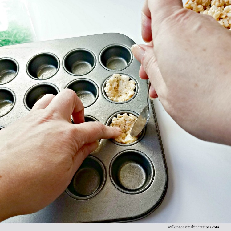 No Bake Rice Krispie Nests topped with mini chocolate robin eggs are a cute treat that is perfect for the Easter holiday. #eastertreat #ricekrispietreats Press Rice Krispie Treats into muffin pan