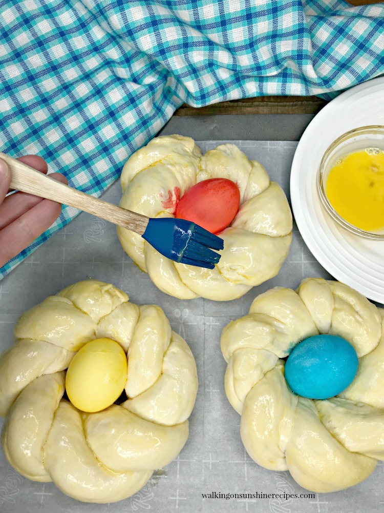 Brush Easter Bread Rings with beaten egg yolk and water. 