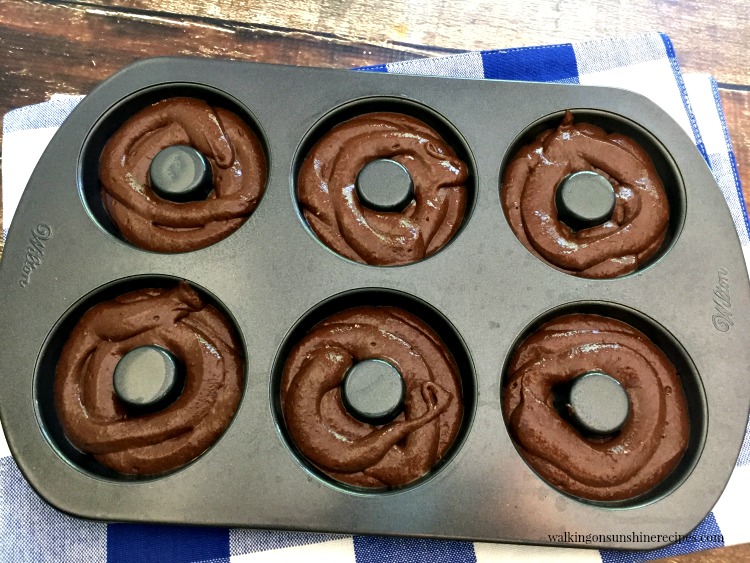Baked Chocolate Donuts start out with a cake mix and are the perfect excuse to enjoy chocolate for breakfast or as a snack any time of day from Walking on Sunshine Recipes. Chocolate Cake Mix donuts in donut pan ready for oven.