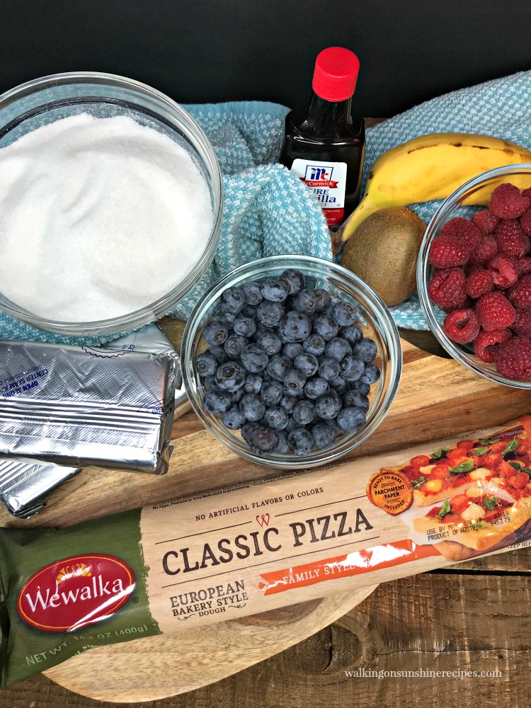 Easter Egg Fruit Pizza - a dessert pizza topped with a pretty pink colored cream cheese frosting and then mixed fresh fruit all in a fun Easter egg shape from Walking on Sunshine Recipes. Ingredients for Easter Egg Pizza