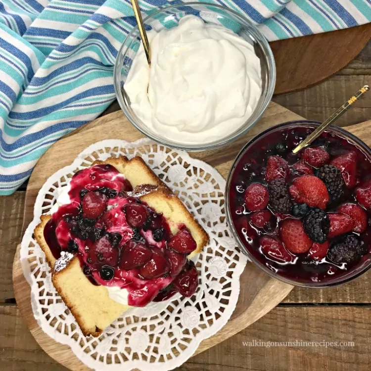 Mixed Berry Compote served over Aunt Betty's Pound Cake recipe with homemade whipped cream in bowl. 
