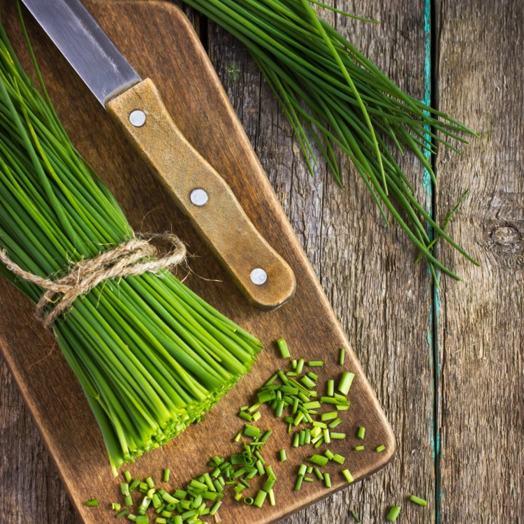 Fresh chives on cutting board sliced. 
