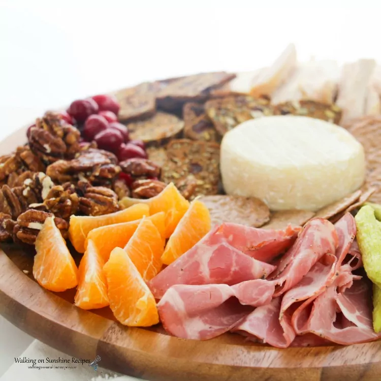 Ham, oranges, nuts, crackers and Brie Cheese on Cheese Board