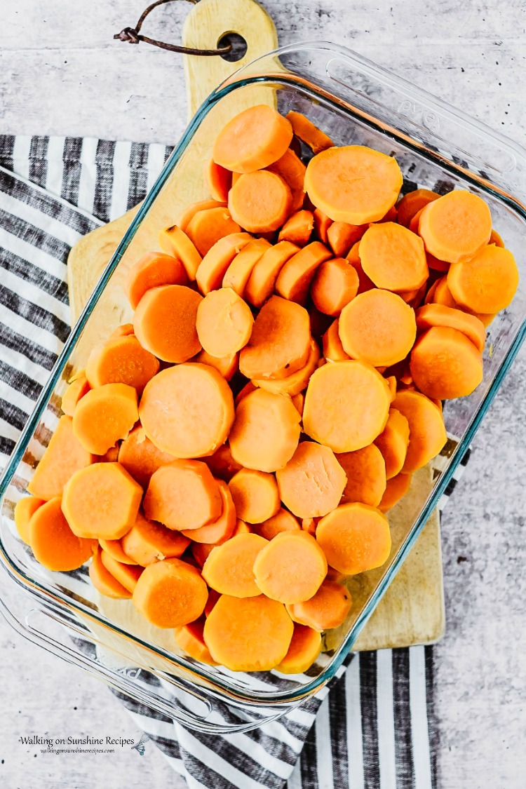 Candied Sweet Potatoes area a side dish staple for a successful holiday celebration. Step-by-step instructions with prep ahead tips included as well from Walking on Sunshine Recipes. Arranged cooked sweet potatoes in casserole dish for Candied Sweet Potatoes