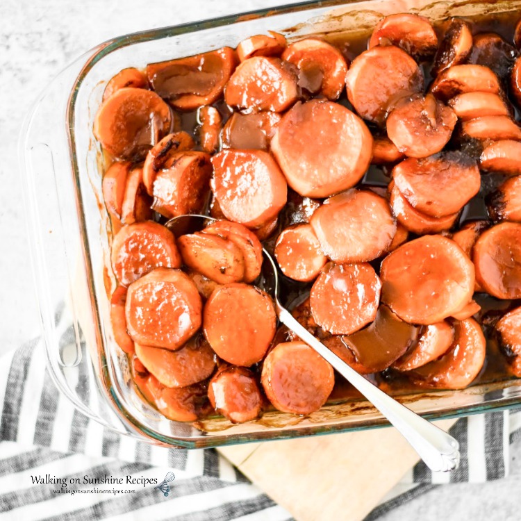 Candied Sweet Potatoes baked in dish with serving spoon from Walking on Sunshine Recipes