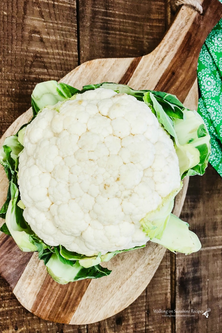 Head of cauliflower on wooden cutting board for Loaded Cauliflower Bites Recipe