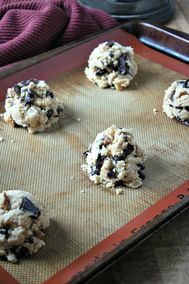 Scoops of Walnut Chocolate Chunk Cookies on baking tray before baking