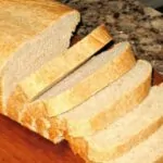Sliced loaf of bread on a wooden cutting board.