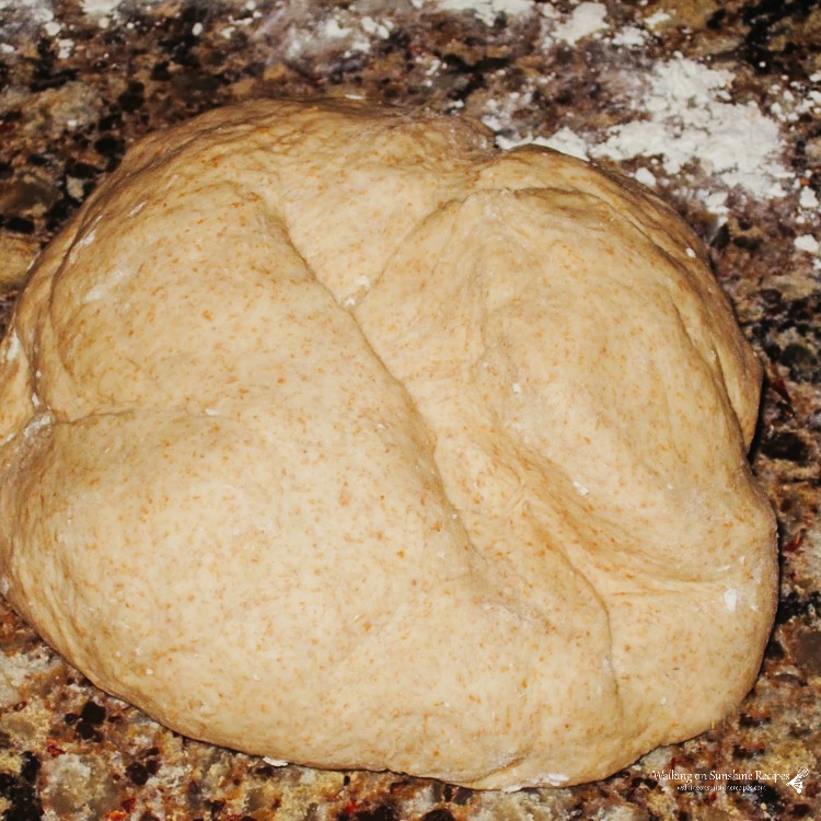 Homemade bread dough on floured surface. 