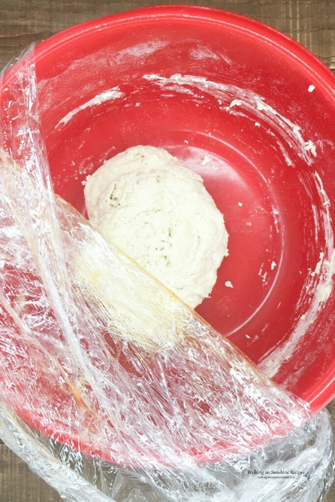 No Knead dough ready to rise overnight in red bowl.