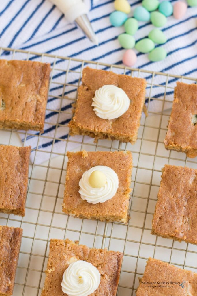 Adding homemade cream cheese frosting to the tops of Candy Cookie Bars.