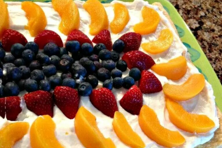 Fruit tart with cream filling and blueberries, strawberries, and peaches.