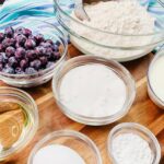 Ingredients for homemade blueberry muffins in glass bowls.