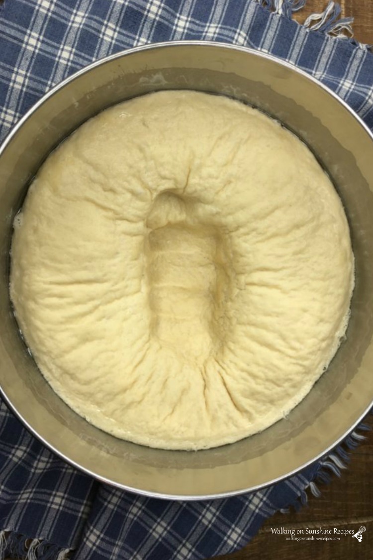 Punch the dough down in the bowl before turning out onto a floured surface to form into pizza shape. 