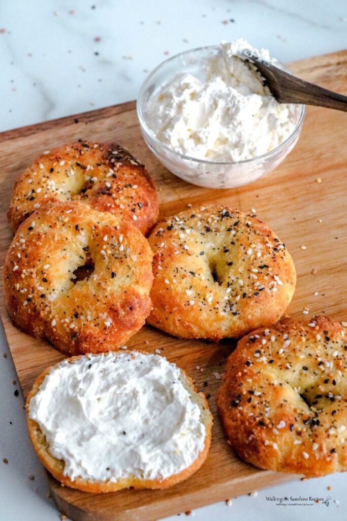 bagels on cutting board with whipped butter. 
