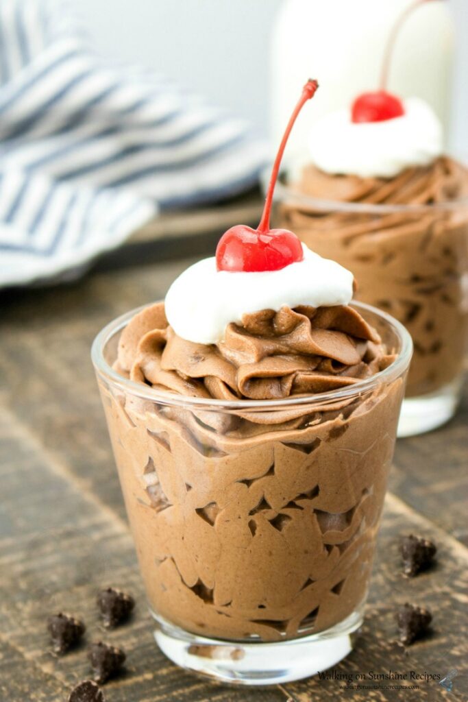 Chocolate Mousse Dessert in individual cups with whipped cream and a cherry on top. 