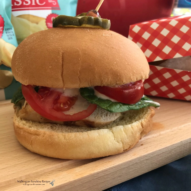Grilled Chicken Sandwiches with tomato, fresh spinach and a pickle on top. 