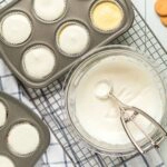 Add sour cream topping to baked Mini Cheesecakes in muffin pan