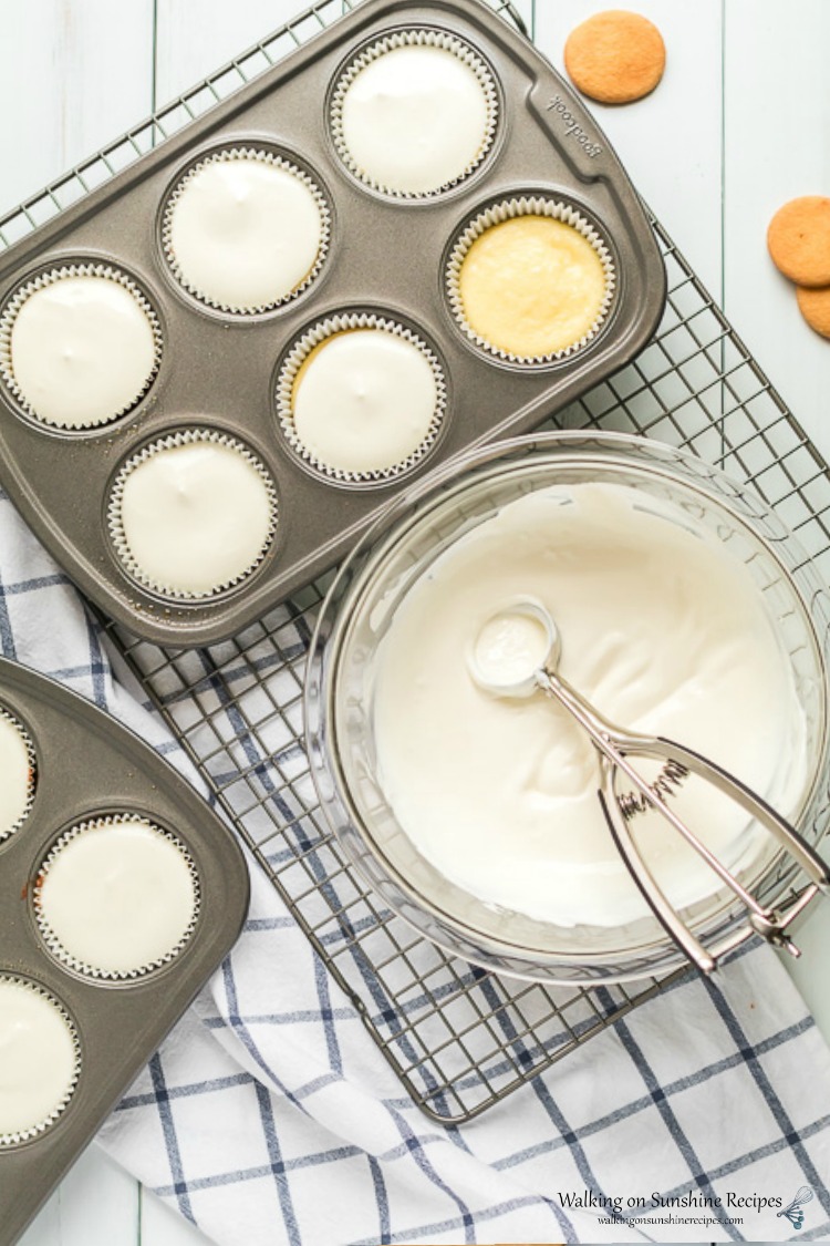 Add sour cream topping to baked Mini Cheesecakes in muffin pan