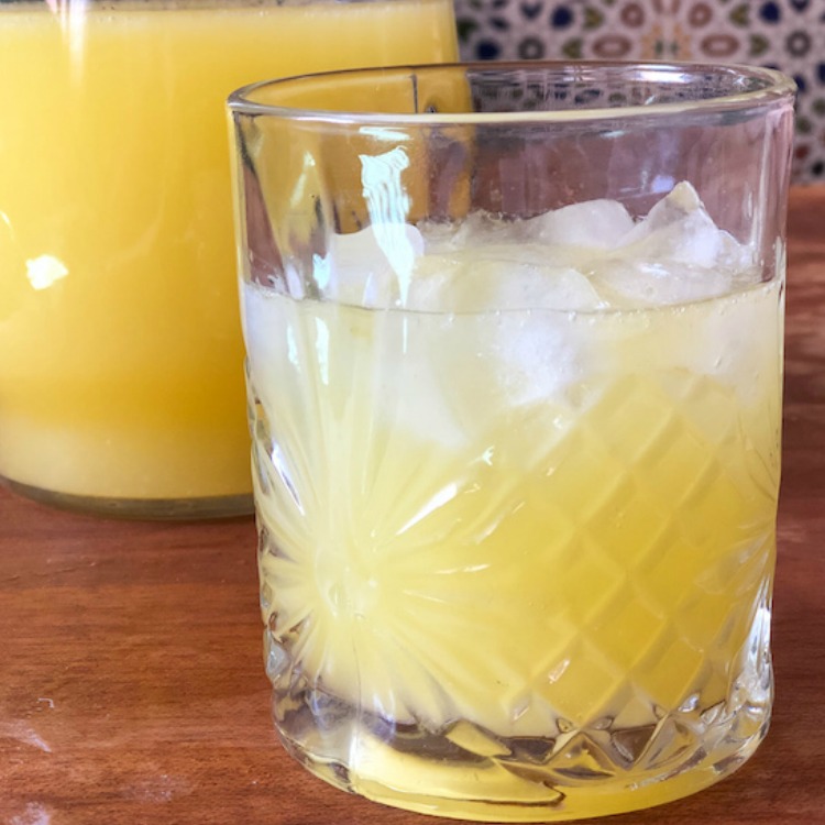 Mint orange lemonade served in a glass with plenty of ice. 