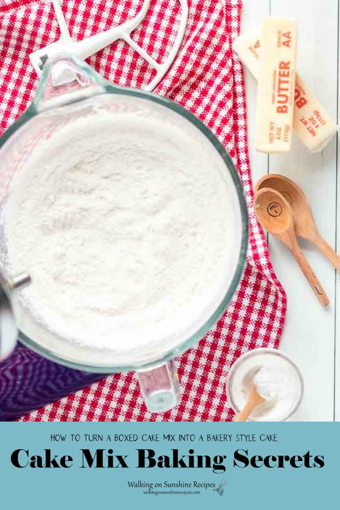 Kitchen Aid Mixer with dry cake mix, sticks of butter and wooden spoons. 