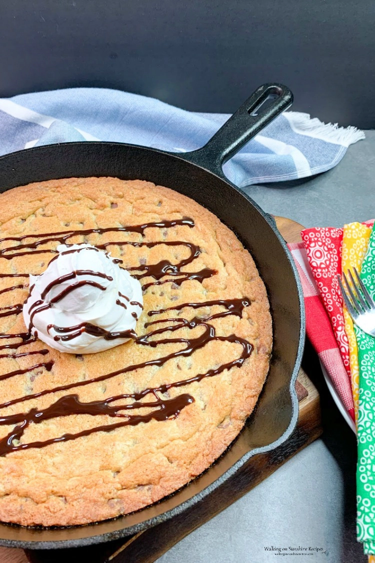 Chocolate Chip Skillet Cookie with whipped cream and chocolate syrup drizzled