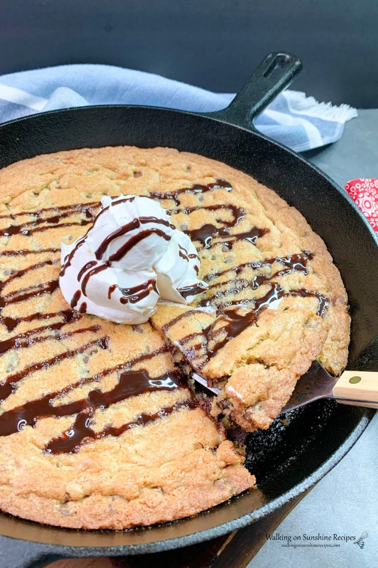 Chocolate chip Skillet cookie with whipped cream and chocolate syrup sliced