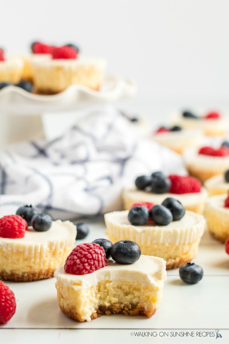 Mini Cheesecakes with Berry Topping and a bite out of one
