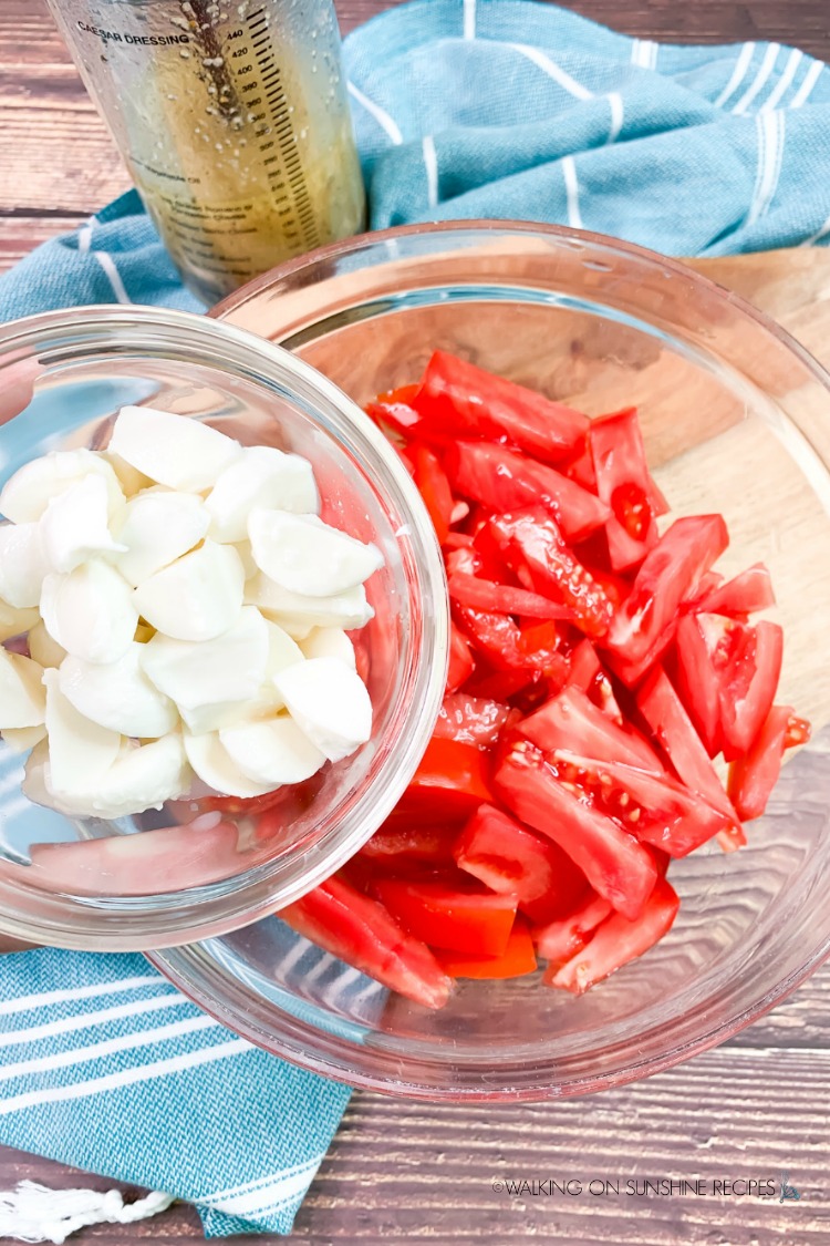 Sliced tomatoes with fresh mozzarella cheese in glass bowls. 