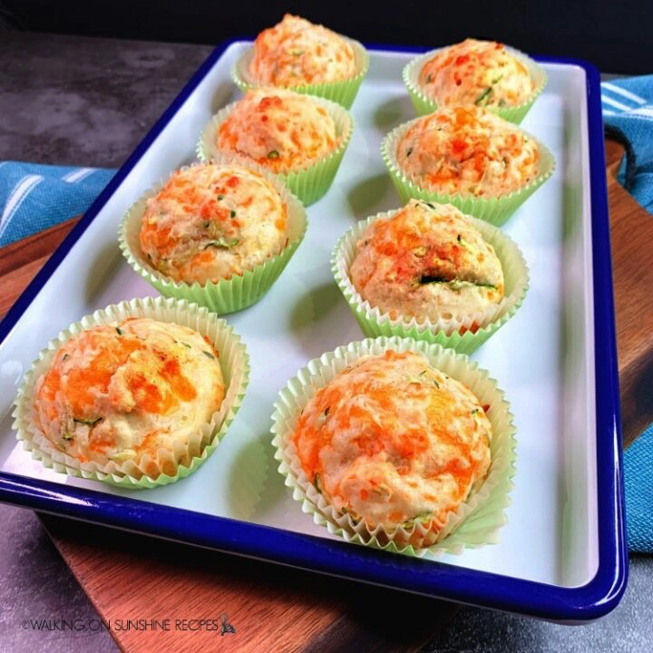 Bisquick Zucchini Cheddar Muffins on white and blue tray and cutting board