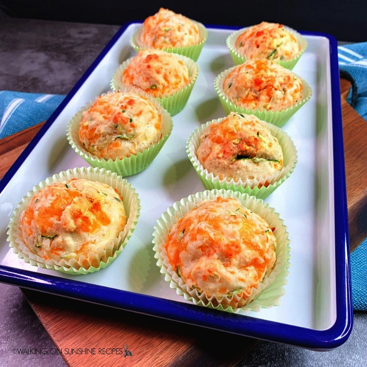 Bisquick Zucchini Cheddar Muffins on white and blue tray and cutting board