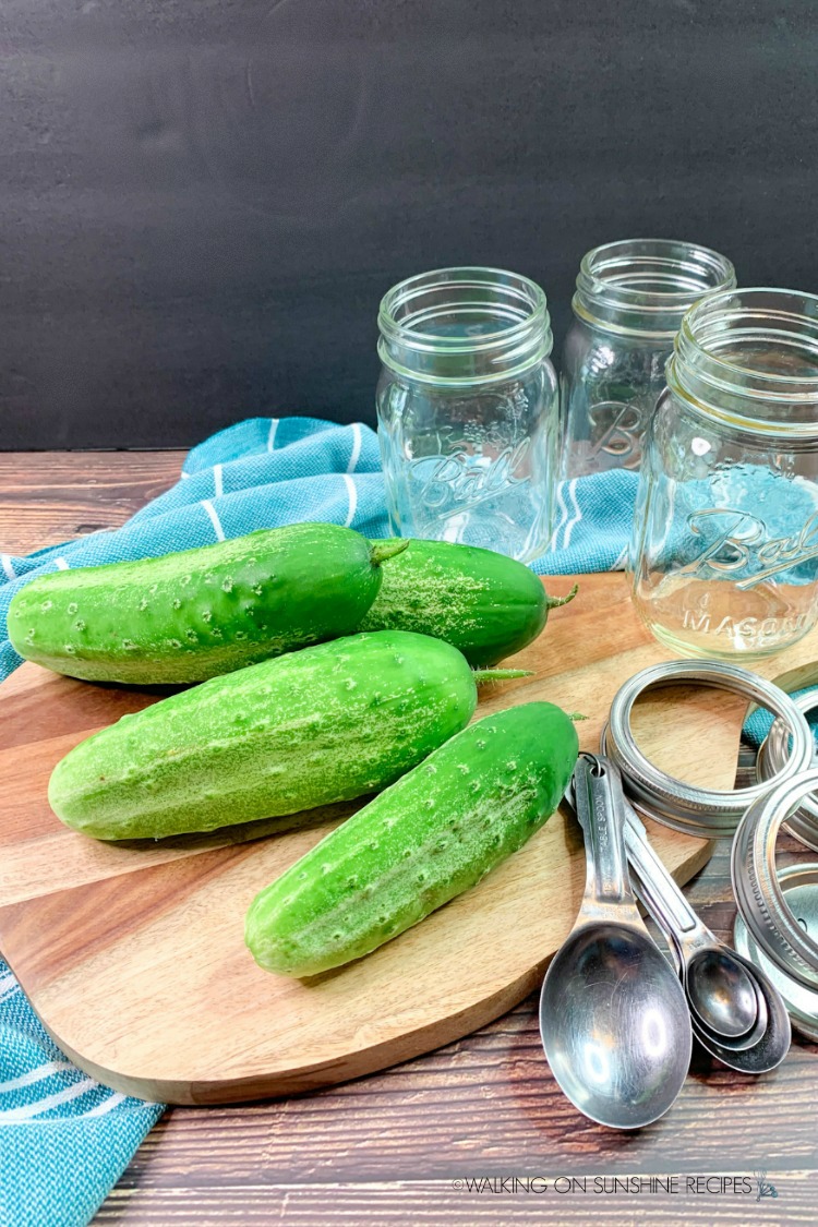 Pickles and mason jar on cutting board
