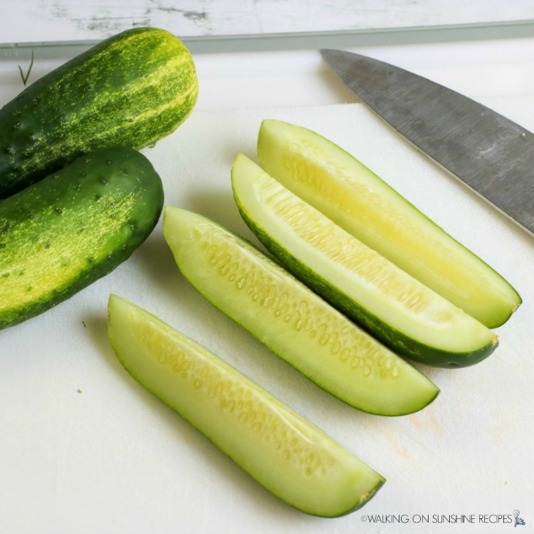 Slice cucumbers on cutting board