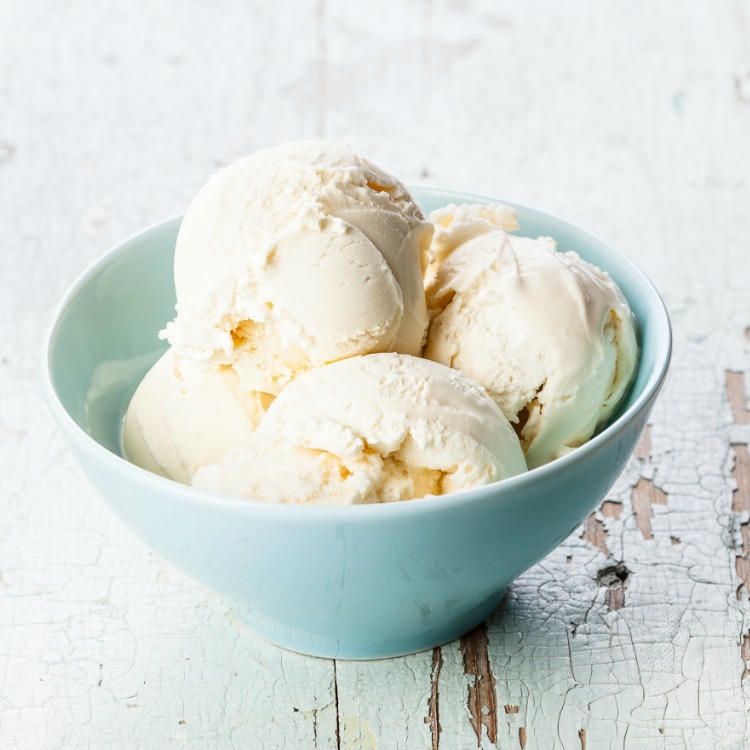 Scoops of vanilla ice cream in aqua bowl.