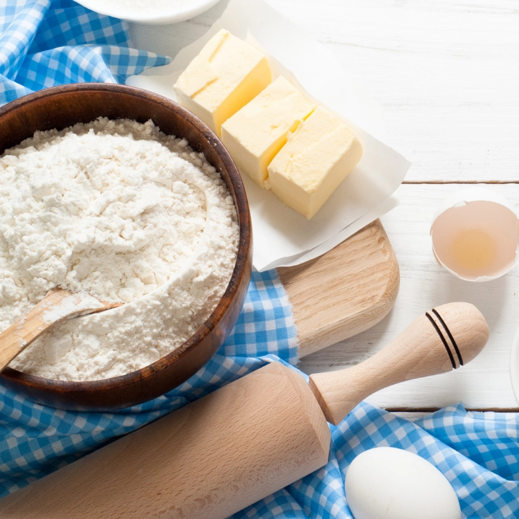 flour, butter, eggs on cutting board. 