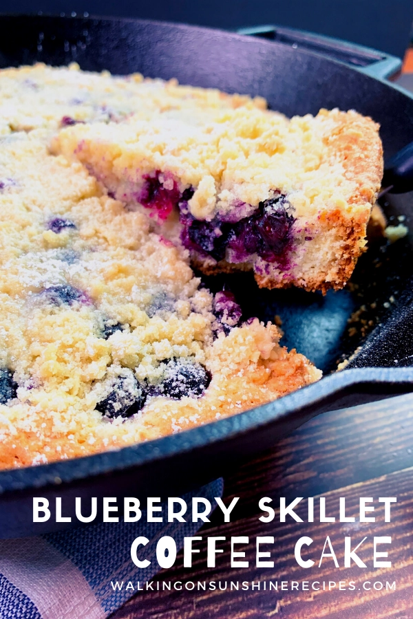 sliced piece of blueberry crumb cake in cast iron skillet. 