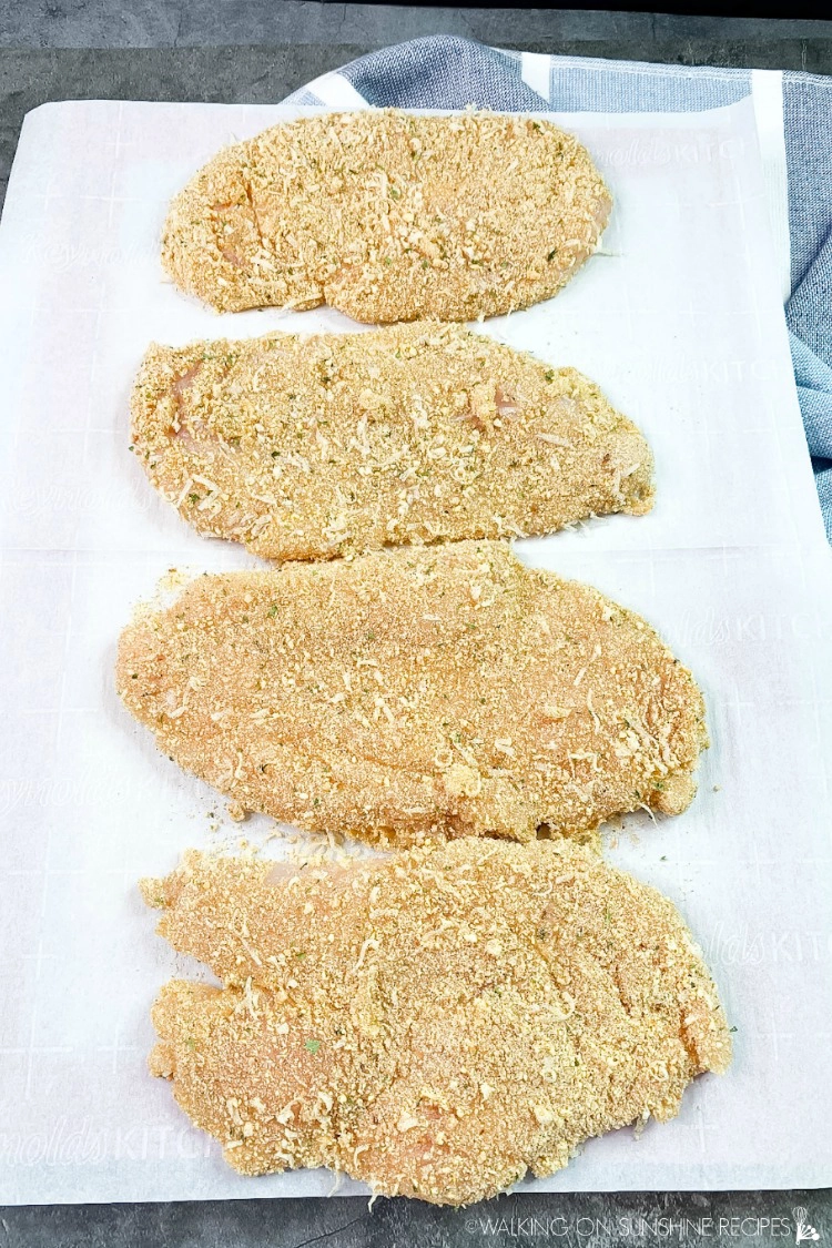 Breaded Chicken Cutlets on cutting board ready to cook