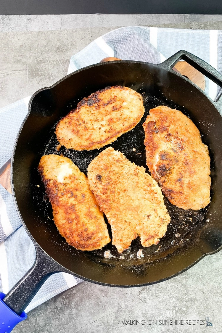 cooked chicken cutlets in cast iron skillet pan. 