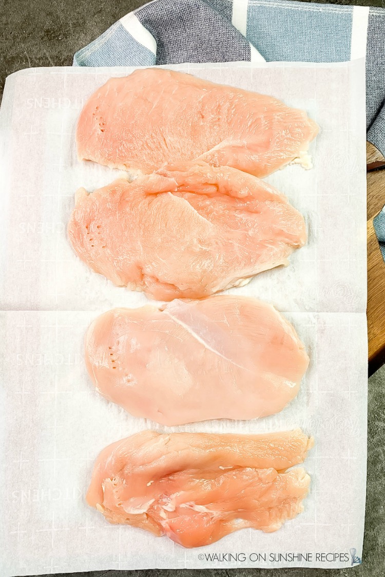 thin chicken cutlets on parchment paper. 
