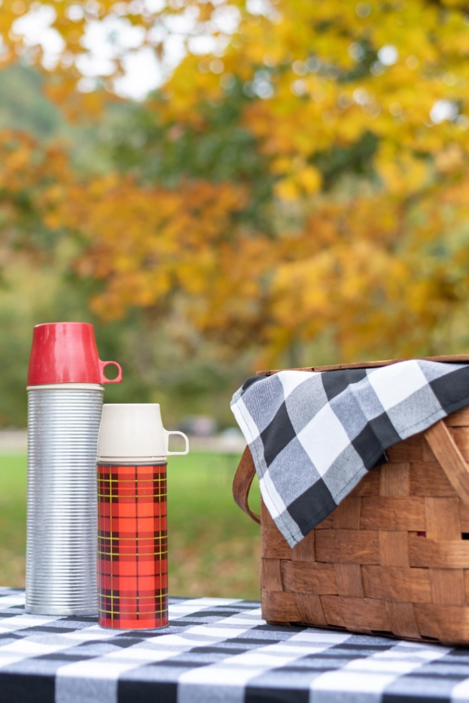 Fall picnic table with basket and two thermos'