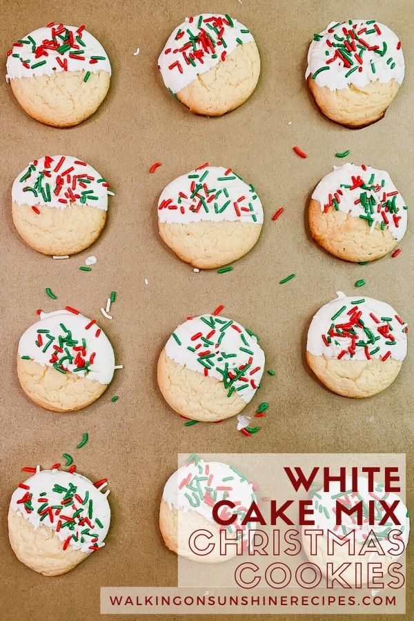 Cake Mix cookies decorated with white icing and sprinkles on baking tray lined with parchment paper. 