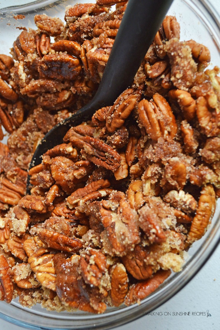Combine sugar, cinnamon with pecans in bowl