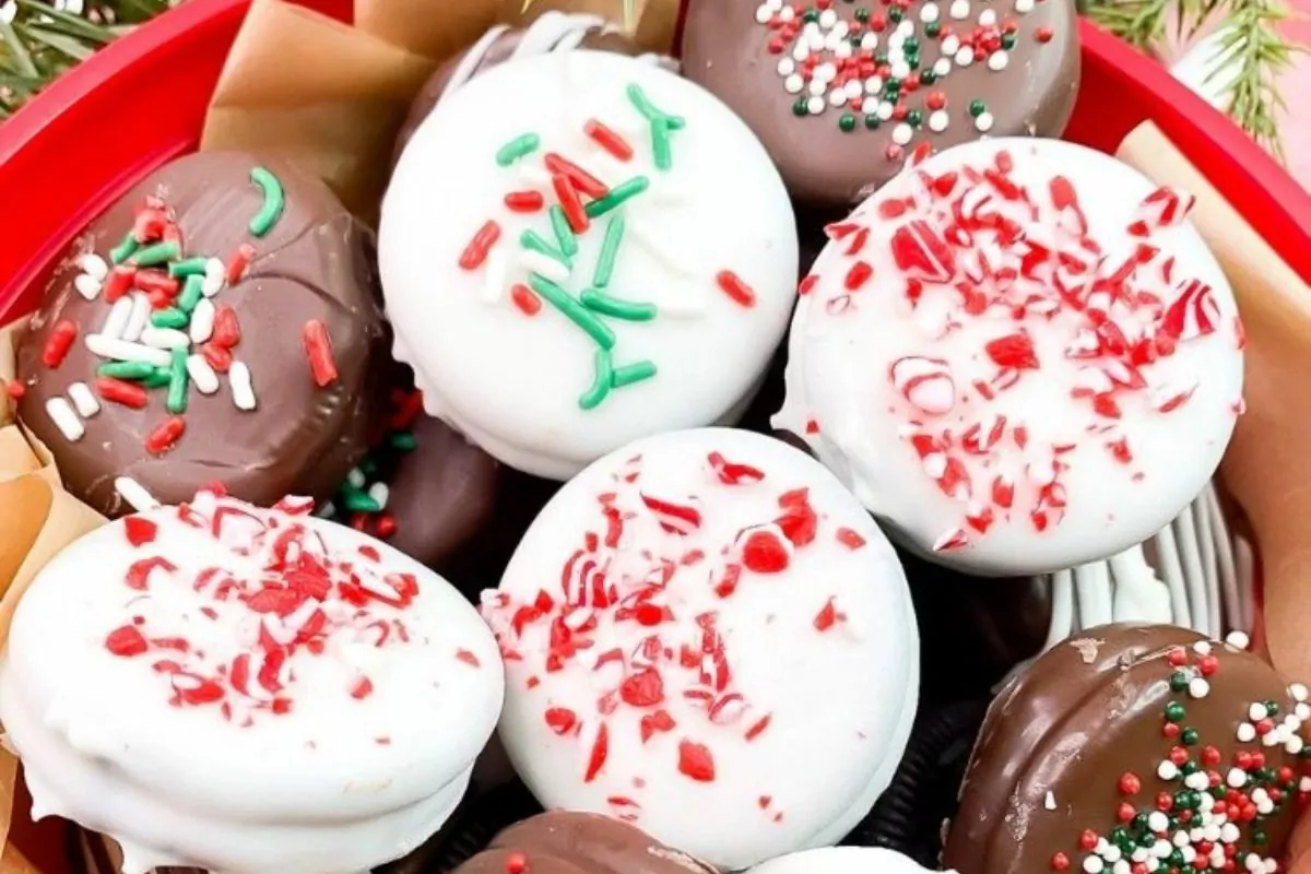 milk chocolate and white chocolate covered oreos with Christmas sprinkles.