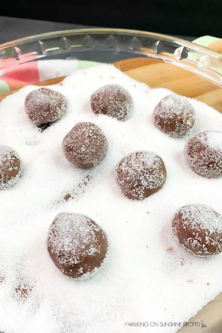 Roll cookie balls in white sugar before placing on baking tray to bake