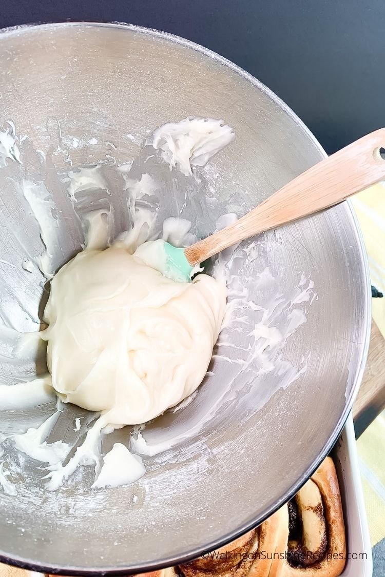 Add homemade cream cheese frosting to freshly baked cinnamon rolls