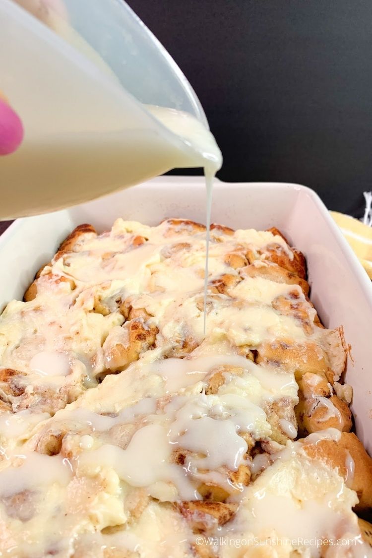 Pouring cinnamon roll icing over baked casserole. 